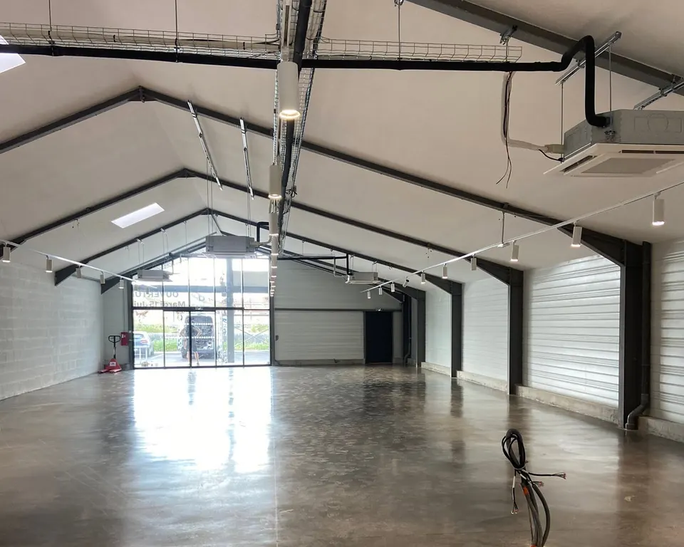 Grand local commercial vide avec des cassettes de climatisation suspendues sous la charpente